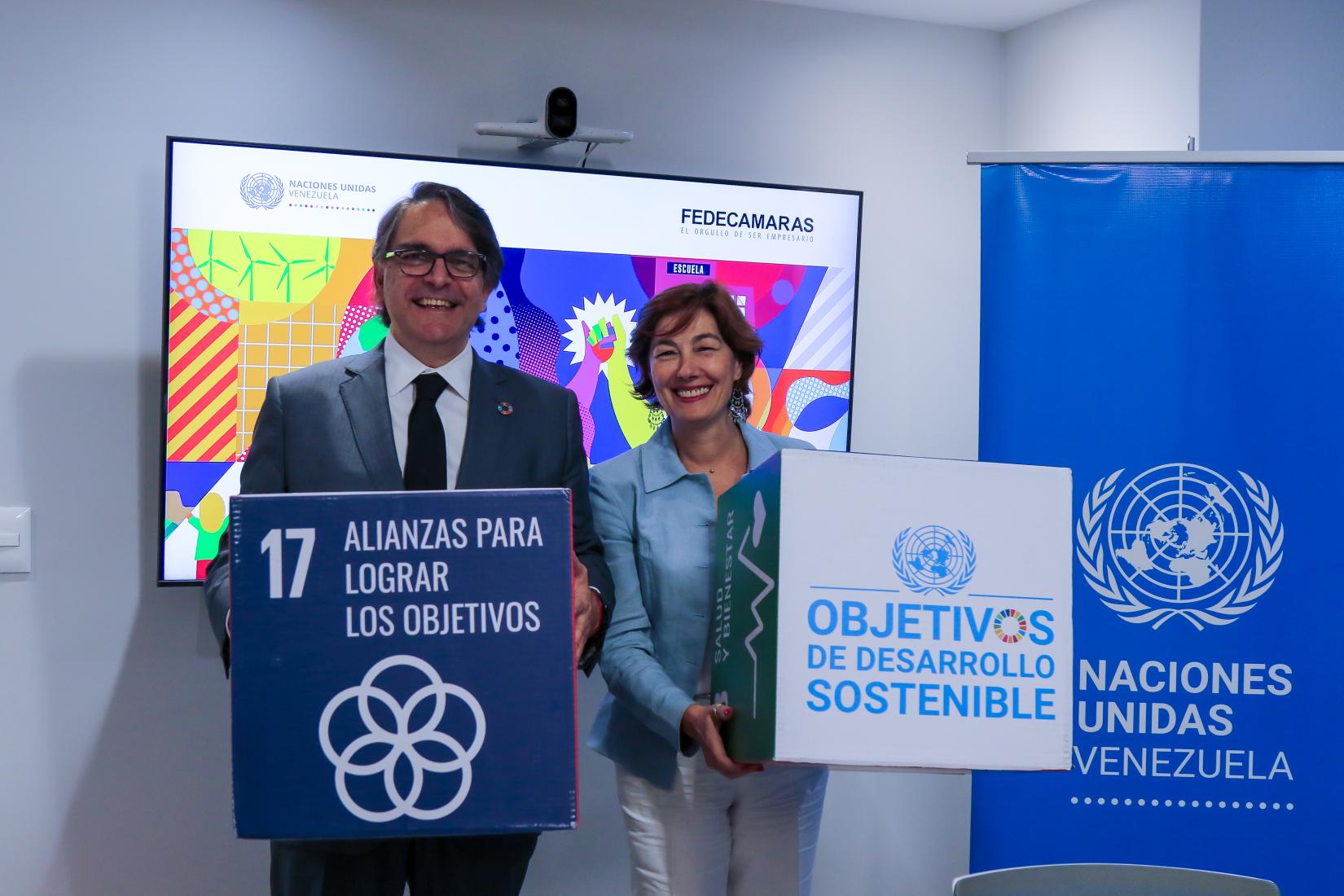 Representantes de la ONU y de Fedecámaras sostienen cubos de los ODS.