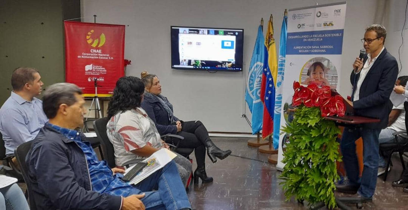 Representante de FAO habla con un micrófono frente a varias personas.