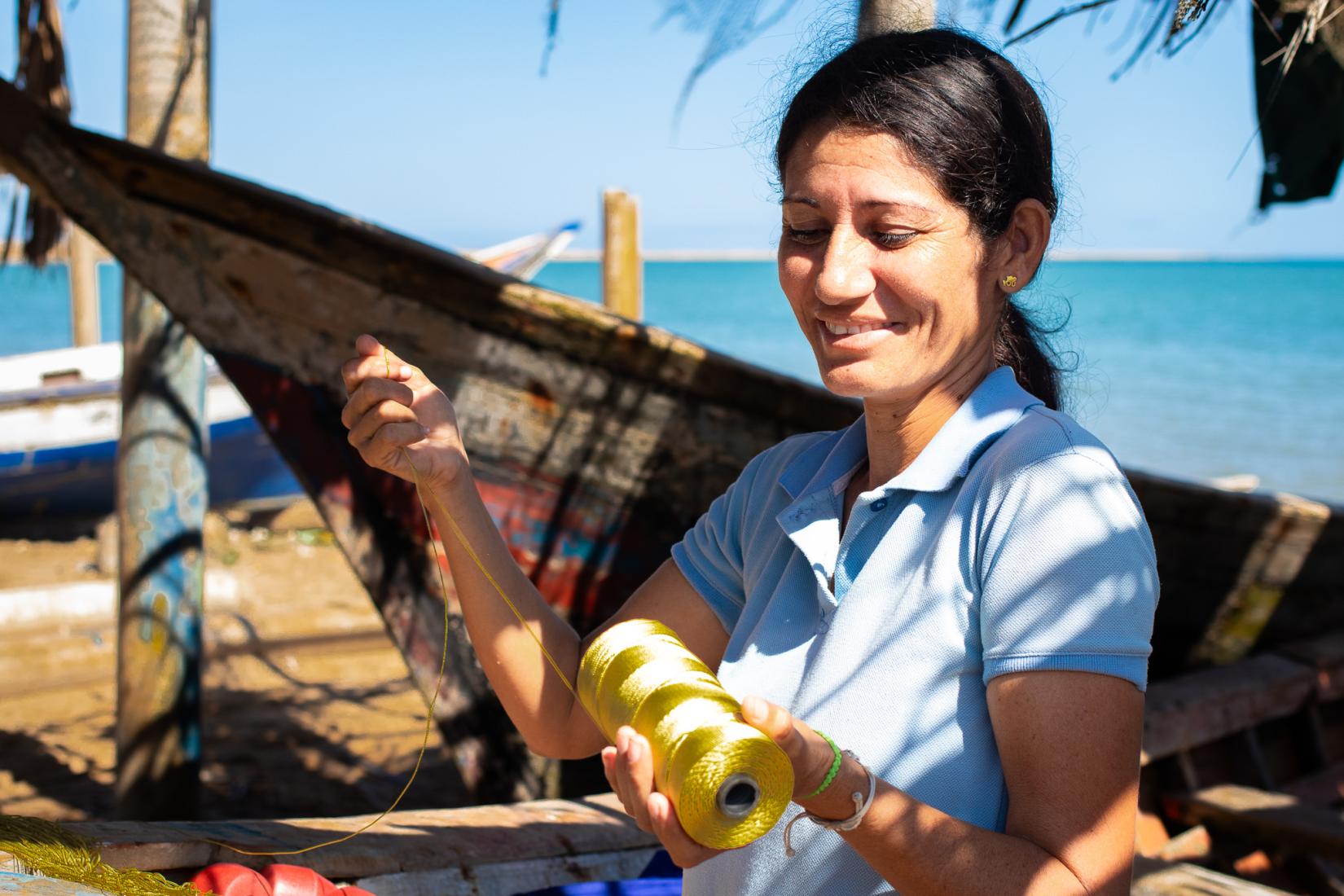 Una mujer trabaja una red de pesca.
