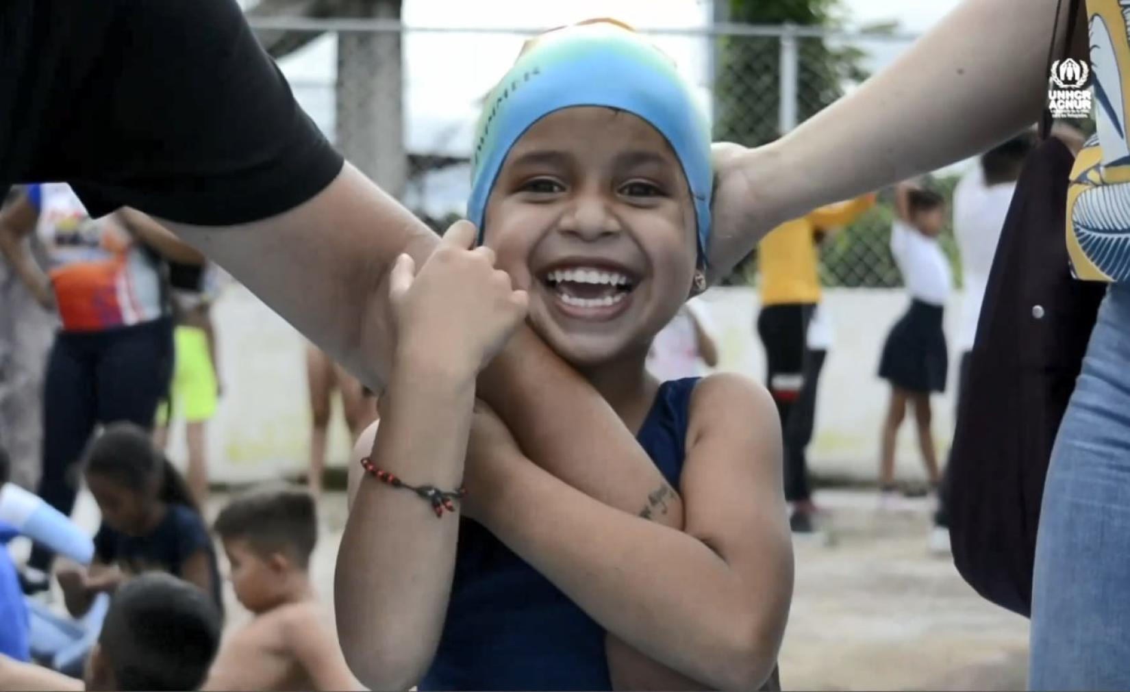 Niña con un gorro de natación sonríe a la cámara