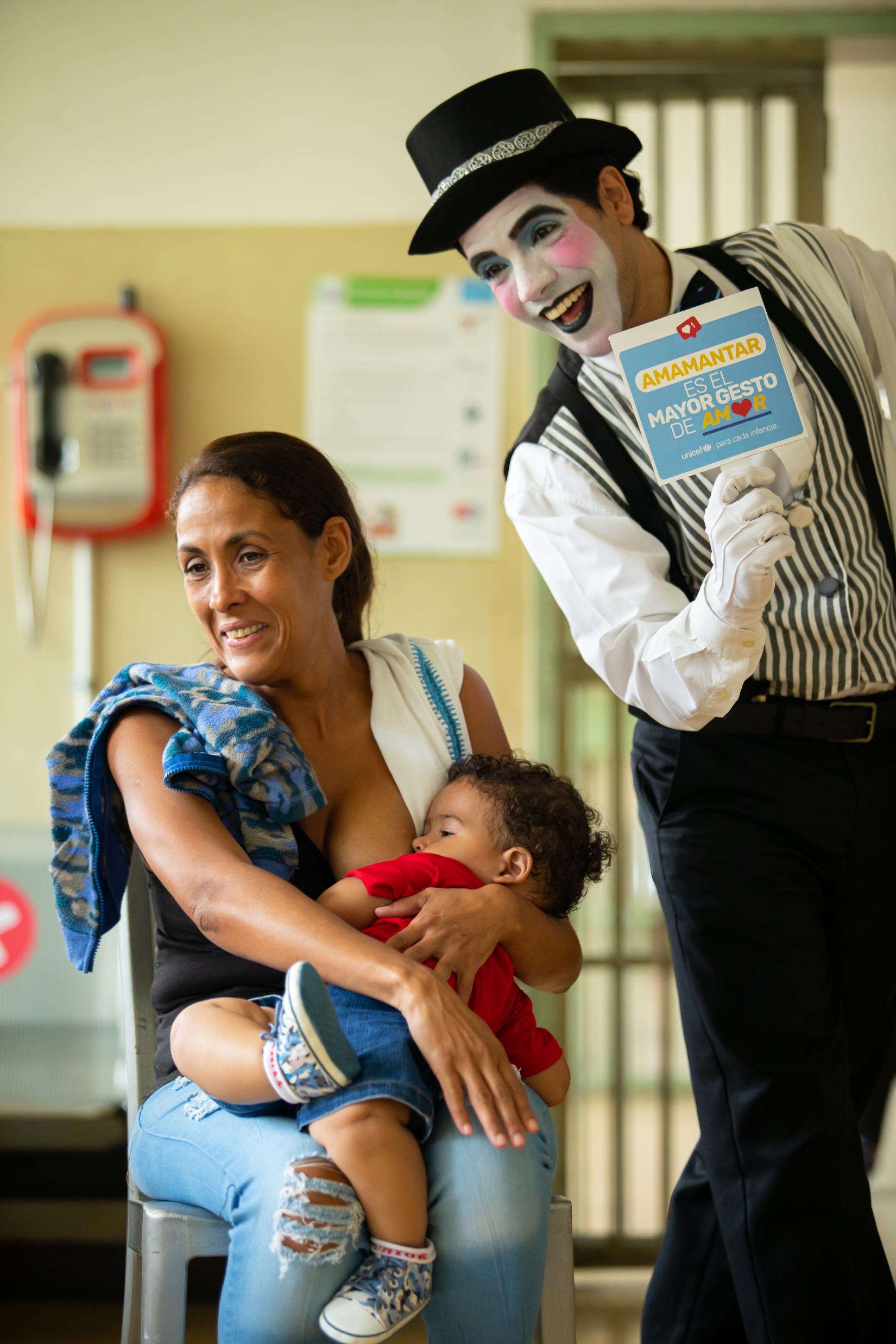 Una madre y su hijo sonríen junto a un mimo.