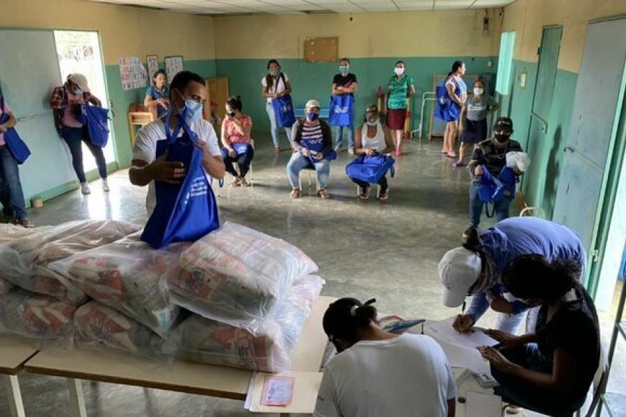 Un padre de familia recibe la ración escolar para llevar a casa
